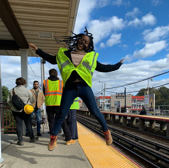 Photograph of a student jumping in midair by a subway stop.
