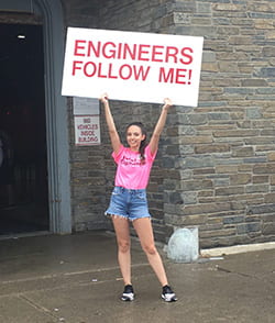 Cornell Engineering peer advisor holding a sign that says, Engineers Follow Me!